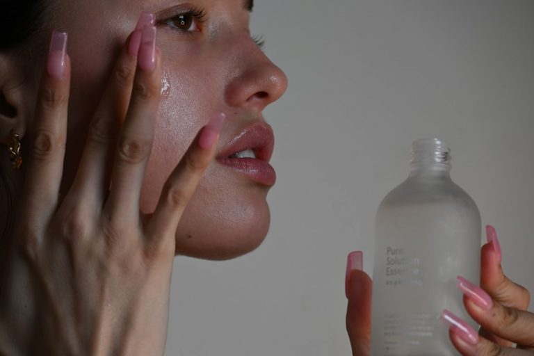 Flat lay of ten fragrance-free moisturizers for acne-prone skin on marble with aloe and green tea.