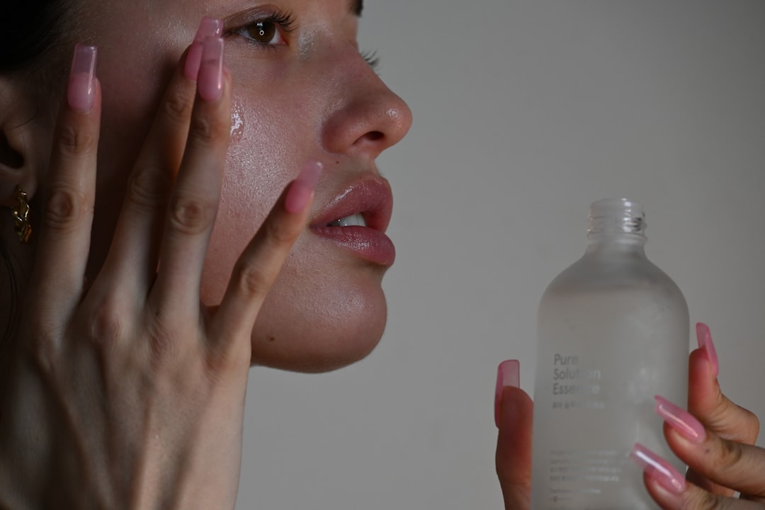 Flat lay of ten fragrance-free moisturizers for acne-prone skin on marble with aloe and green tea.